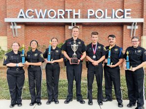 image of Acworth police cadets carrying awards and trophies